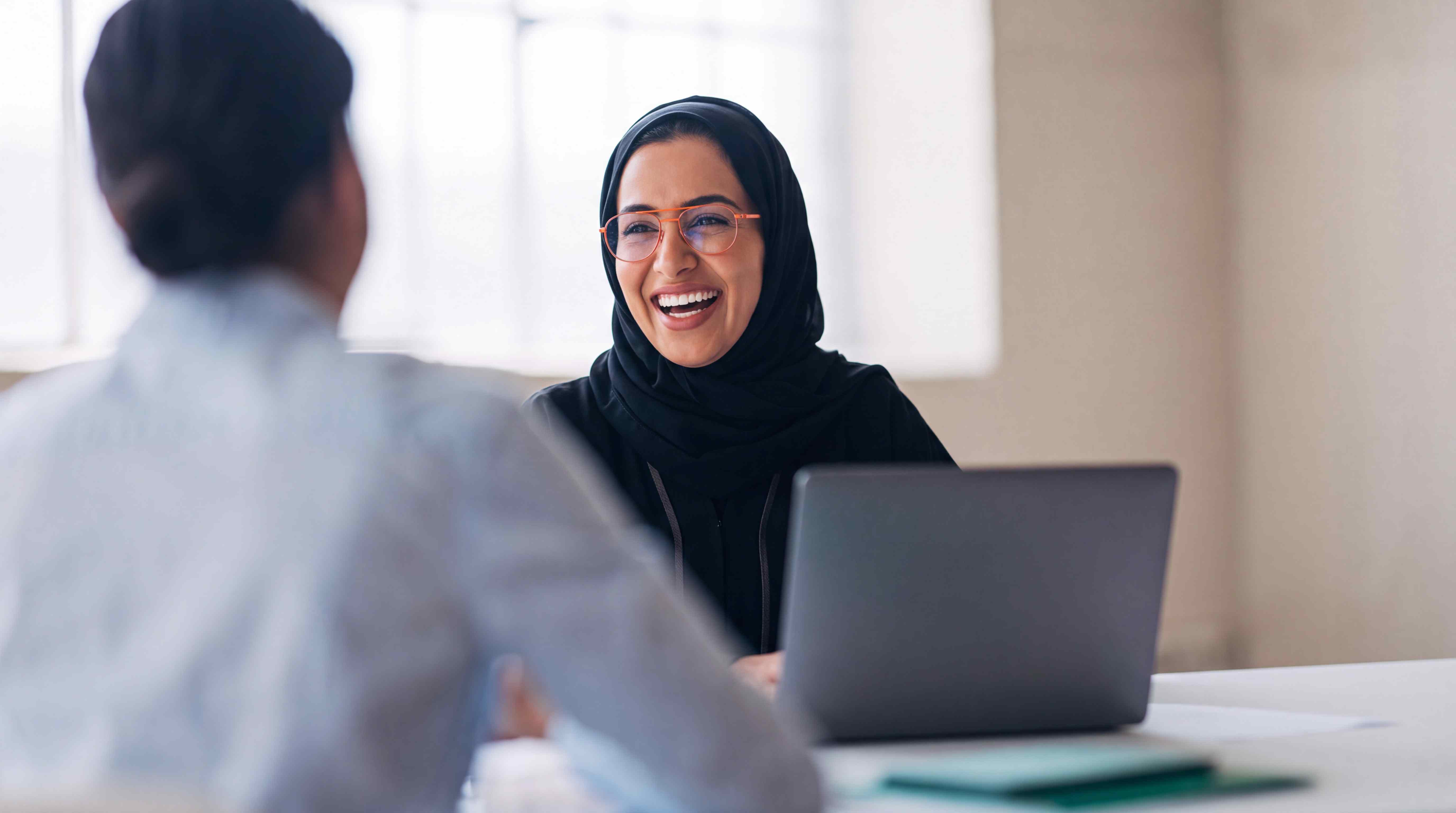 An adult learner smiling during a language conversation session with a classmate